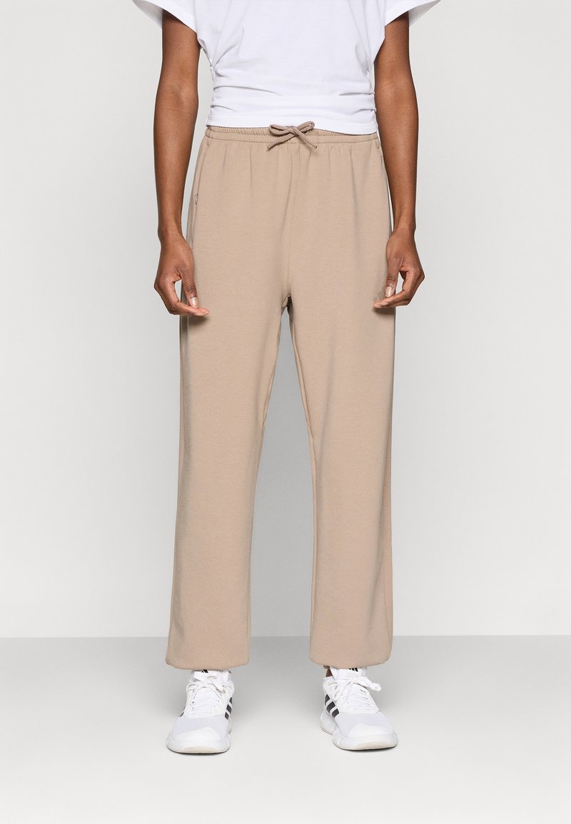 Ανοιχτόμπεζ φόρμας με ελαστική μέση και κορδόνι. Άνετη εφαρμογή, ευθεία γραμμή στα πόδια, κατασκευασμένη από μαλακό βαμβακερό μείγμα.