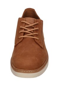 Chaussures en cuir marron à lacets, avec un bout arrondi, une texture lisse et une semelle beige contrastante. Présente des lacets beige assortis et des détails de couture.