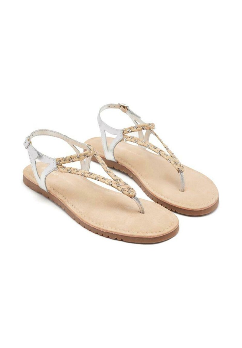 Sandalía blanca con acentos dorados, con tiras trenzadas y suela plana de un suave tono marrón claro, que cuenta con hebilla ajustable en el tobillo y diseño abierto.