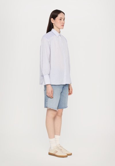 Lyse blå og hvite stripete skjorte med knapper, avslappet passform, lange ermer; kombinert med denimshorts og lyse joggesko med striper.