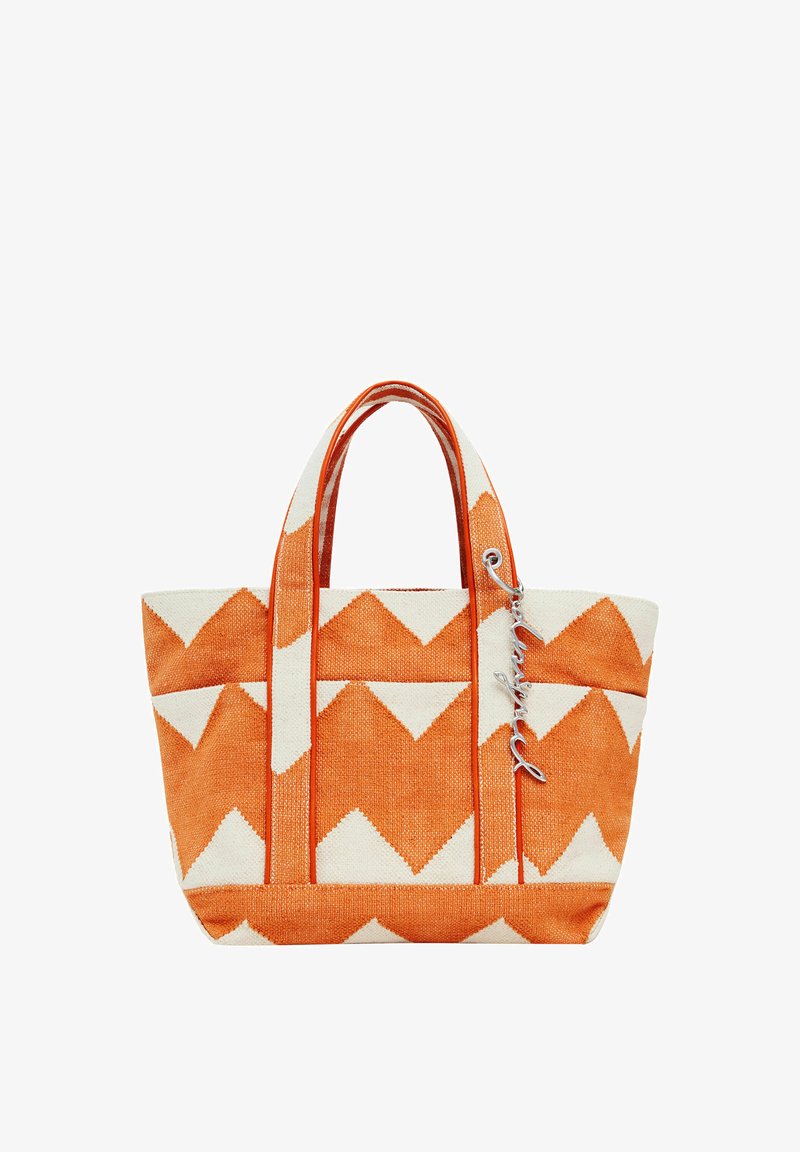 Narancssárga és fehér vászontáska cakkos mintával, dupla fogantyúval és az egyik fogantyúhoz rögzített kiegészítő címkével. Strukturált anyag.