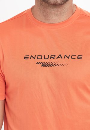Orange tränings t-shirt tillverkad av lättviktig tyg, med en svart "ENDURANCE" logotyp och grafiska inslag på framsidan.