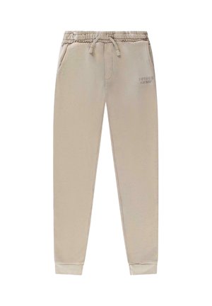 Lichtbeige joggingbroek gemaakt van zacht materiaal, met een elastische tailleband met trekkoord, zijzakken en geribbelde boorden.