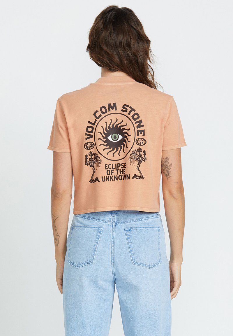 T-shirt corta pesca con un design grafico nero che presenta un occhio, un sole e scheletri, realizzata in morbido cotone.