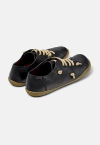 Black leather shoes with beige laces, rounded toe design, and rubber sole. Features stitched accents and gentle curvature in profile.