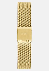 Zlatni metalni sat s pletenom mrežastom narukvicom, sa kopčom ugraviranom s "GUESS." Glatka tekstura i pravokutni oblik s sjajnom završnom obradom.