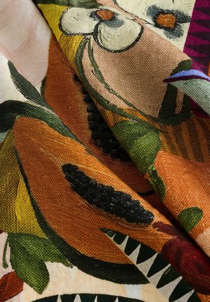 Colorful fabric featuring floral patterns in shades of orange, green, and black with textured surface details and a complex design layout.