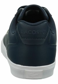 Lacoste sneakers in navy leather with a textured finish. White rubber sole with embossed logo on heel and lace-up design.