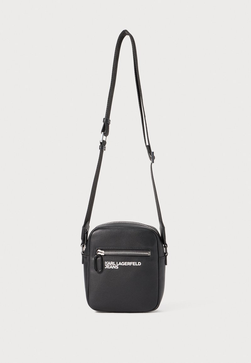 Borsa a tracolla nera realizzata in materiale sintetico, con tasca frontale con zip, tracolla regolabile e dettaglio del logo in bianco.