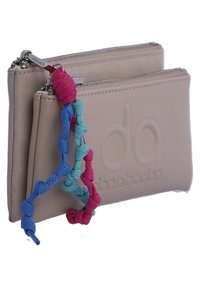 Cartera sintética beige con logotipo en relieve, compartimentos de doble cremallera y una correa trenzada colorida en rosa, azul y turquesa.