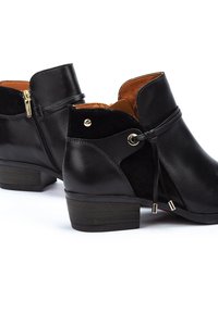 Botas negras hasta el tobillo que presentan una combinación de cuero liso y de ante, punta redonda, tacón corto en bloque, cremallera lateral y detalles decorativos de encaje.