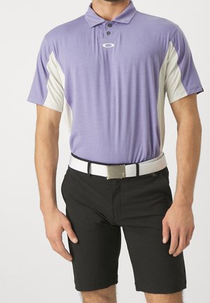 Polo court violet à manches courtes avec des boutons noirs et des accents blancs. Assorti à un short noir et une ceinture blanche avec une boucle en argent.