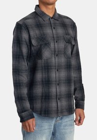 Schwarz- und grau kariertes Flanellhemd mit langen Ärmeln, Knopfleiste auf der Vorderseite, zwei Brusttaschen und klassischem Kragenentwurf.
