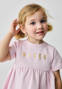 Jasnoróżowa sukienka z krótkimi rękawami, z marszczonym dołem i koronkowym wykończeniem na ramionach, wyróżniona złotym logo "BAKER by TED BAKER".