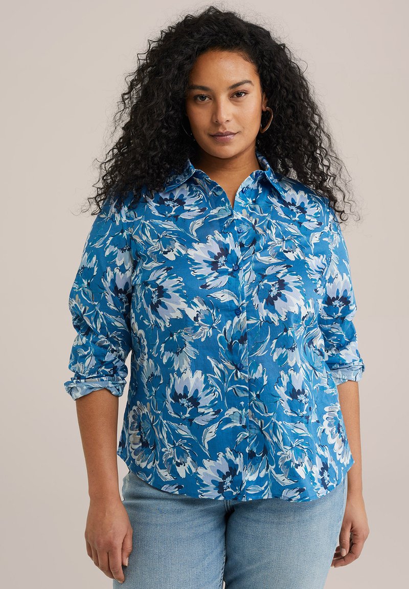 Blå blommig skjorta med knappar och uppvikta ärmar, prydd med vita och mörkblå blommor. Tillverkad av lättviktsmaterial med en frisk finish.