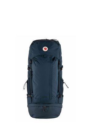 Mochila de senderismo de color azul marino hecha de tejido duradero, con correas ajustables, tapa superior y un parche de logo circular. Múltiples bolsillos externos.