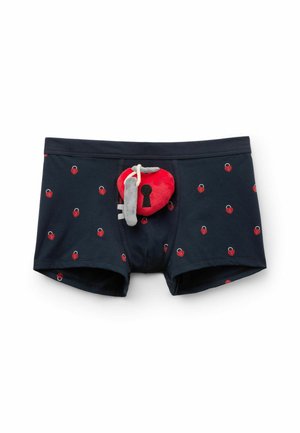 Granatowe bokserki męskie z nadrukami czerwonych serc w kształcie kłódek oraz pluszową czerwoną kłódką w kształcie serca przymocowaną na środku z przodu.