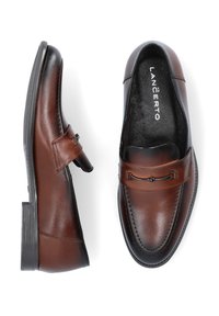 Brązowe skórzane mokasyny o eleganckim designie, z ozdobnym metalowym paskiem, okrągłym noskiem i niską czarną gumową podeszwą.