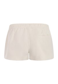 Beige shorts med elastisk taljebånd og en enkelt baglomme på højre side, vist fra bagfra.