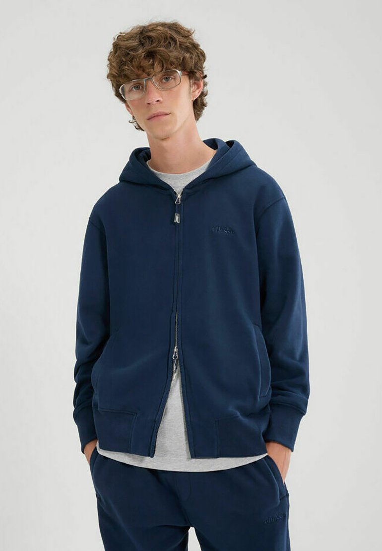 Felpa con cappuccio blu navy, dotata di zip, due tasche frontali, polsini a costine e un logo discreto. Realizzata in tessuto morbido e liscio, design minimalista.