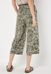 Grüne, blumengemusterte Cropped-Hosen mit elastischem Bund, mit weißen Blatt- und Blumenmotiven, aus leichtem Stoff gefertigt.