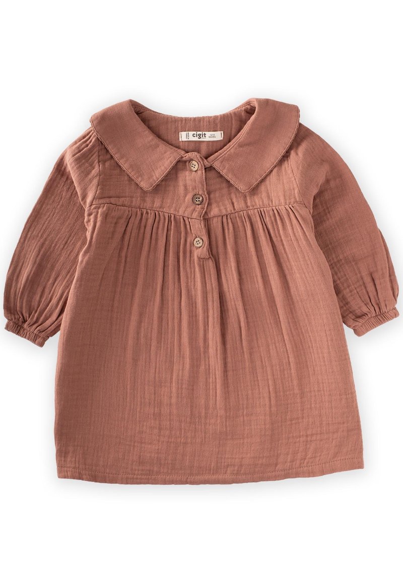 Blusa color ruggine con colletto, maniche lunghe a sbuffo e chiusura con bottoni. Realizzata in un tessuto morbido e testurizzato con dettagli arricciati in vita.