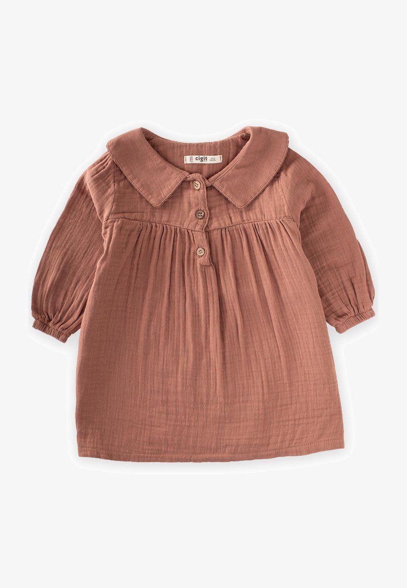 Blůza v rezavé barvě s límečkem, dlouhými nafouknutými rukávy a zapínáním na knoflíky. Vyrobena z měkké, strukturované látky s nařasením v oblasti pasu.