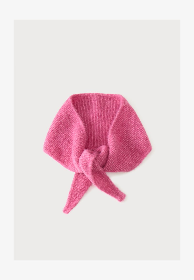 Écharpe tricotée rose pâle douce nouée en un nœud lâche sur un fond clair.