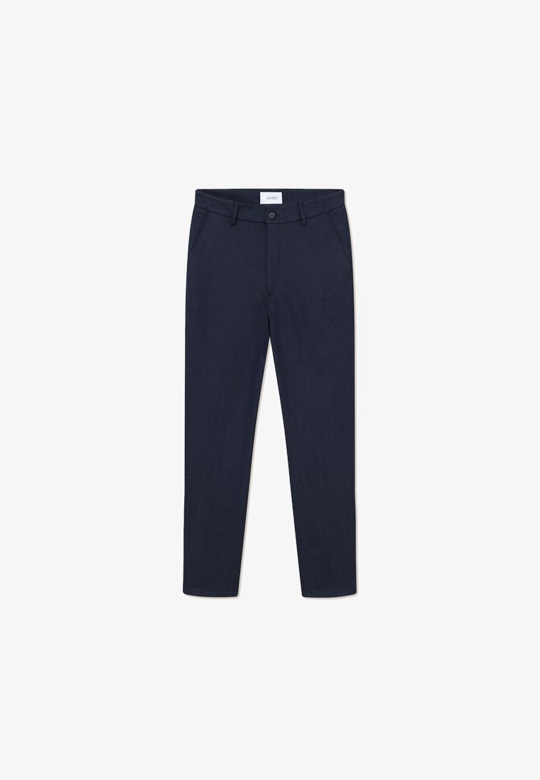 Tumed sinise värvi vormitud püksid, mis on valmistatud siledast kangast; sisaldavad eesolevaid taskuid, tavalist vööd ja kitsenevaid jalgu.