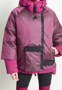 Puffig huva jacka i mörk magenta och ljusrosa, med en framdragkedja, elastiska manschetter och en sidoficka med bältesdetalj.