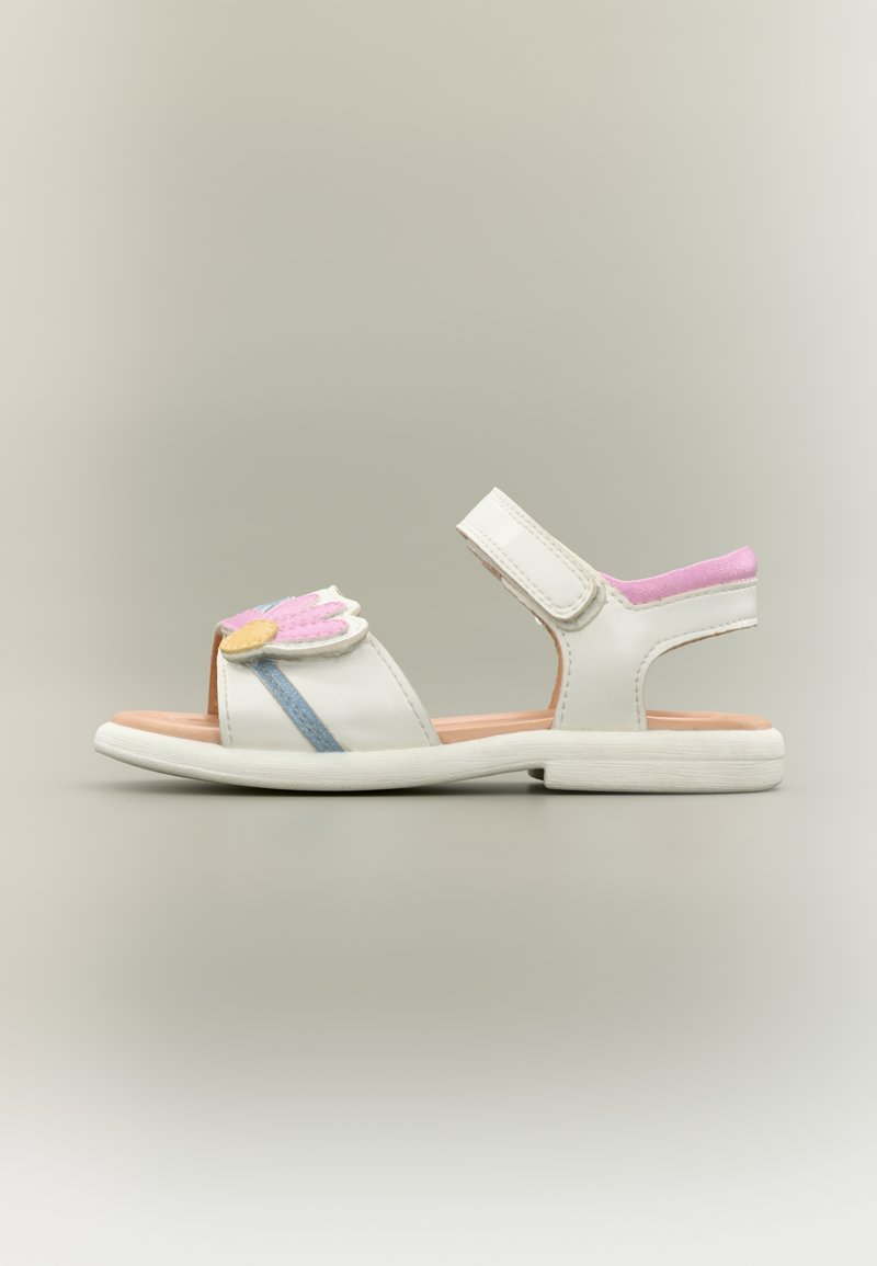 Λευκό σανδάλι με ανοιχτή μύτη και τακούνι, με σχέδιο λουλουδιού σε ροζ, κίτρινο και μπλε στο μπροστινό μέρος. Κλείσιμο με λουράκι βέλκρο και υφή στη σόλα.