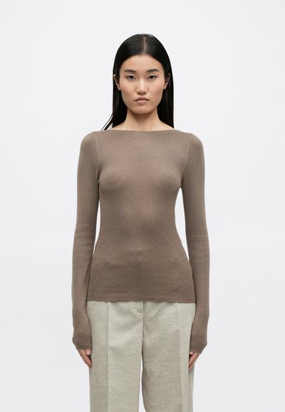 Garais piedurknes, brūns, ribots adījums ar plašu laivu izgriezumu un pagarinātām aprocēm, kombinēts ar gaiši pelēkiem, savītu biksēm.