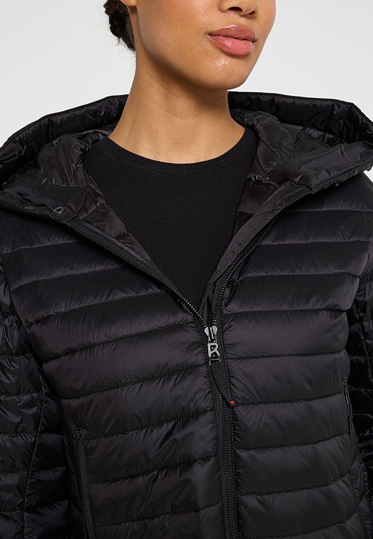 Schwarze Pufferjacke mit Kapuze, ausgestattet mit einem gesteppte Design, einem Reißverschluss vorne und kleinem Logo. Glatte Textur und taillierte Form.