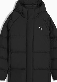 Zwarte pufferjack met kap. Gemaakt van lichtgewicht, gewatteerd materiaal. Heeft een ritssluiting en een wit Puma-logo op de borst.