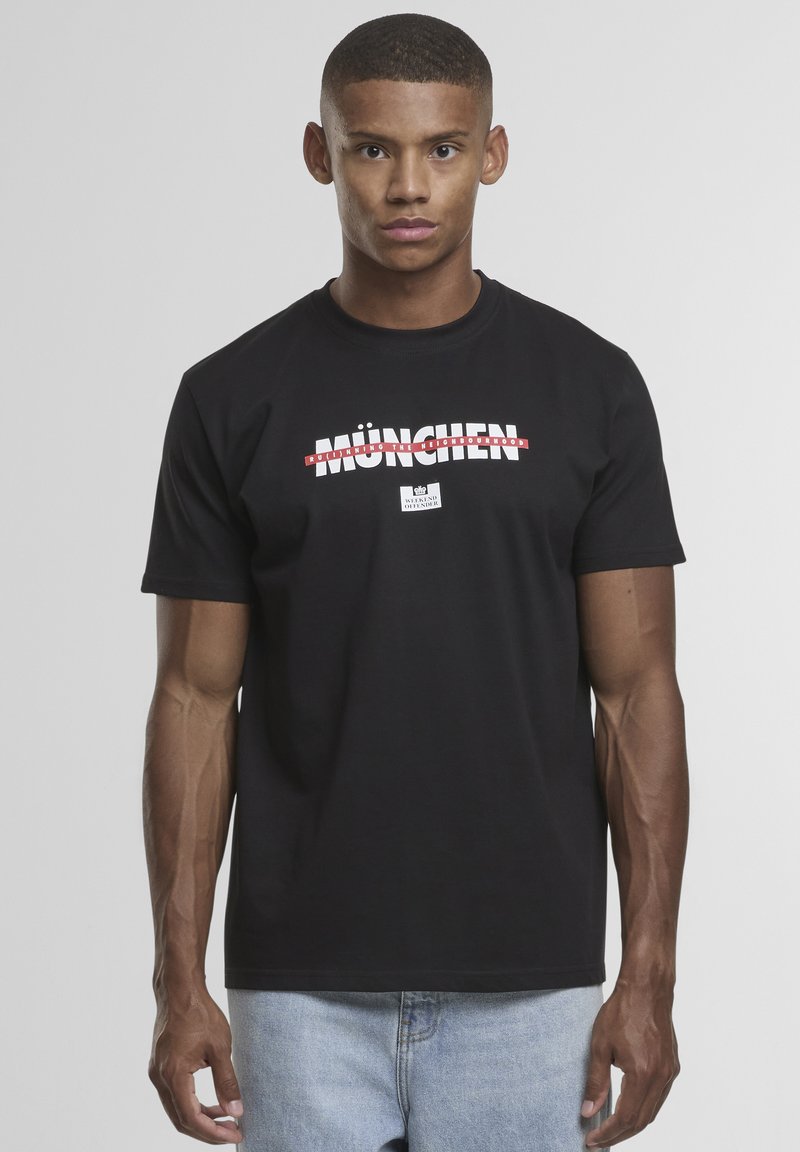 Schwarzes Baumwoll-T-Shirt mit einem Grafikdesign, das "MÜNCHEN" in rotem und weißem Text zeigt. Kurze Ärmel, Rundhalsausschnitt und eine lockere Passform.
