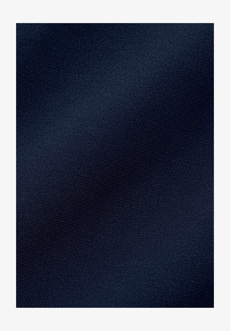 Dunkel marineblauer Stoff mit feiner gewebter Struktur, der leichte Falten und weiches Licht auf der Oberfläche zeigt.