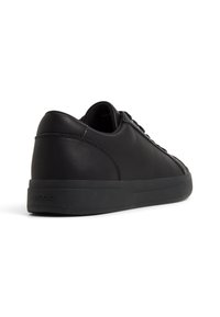 Mustat nahkakengät, joissa on pyöreä kärki, litteä musta kumipohja ja ommellut yksityiskohdat. Yksinkertainen muotoilu, jossa on minimaalinen brändäys kantapäällä.