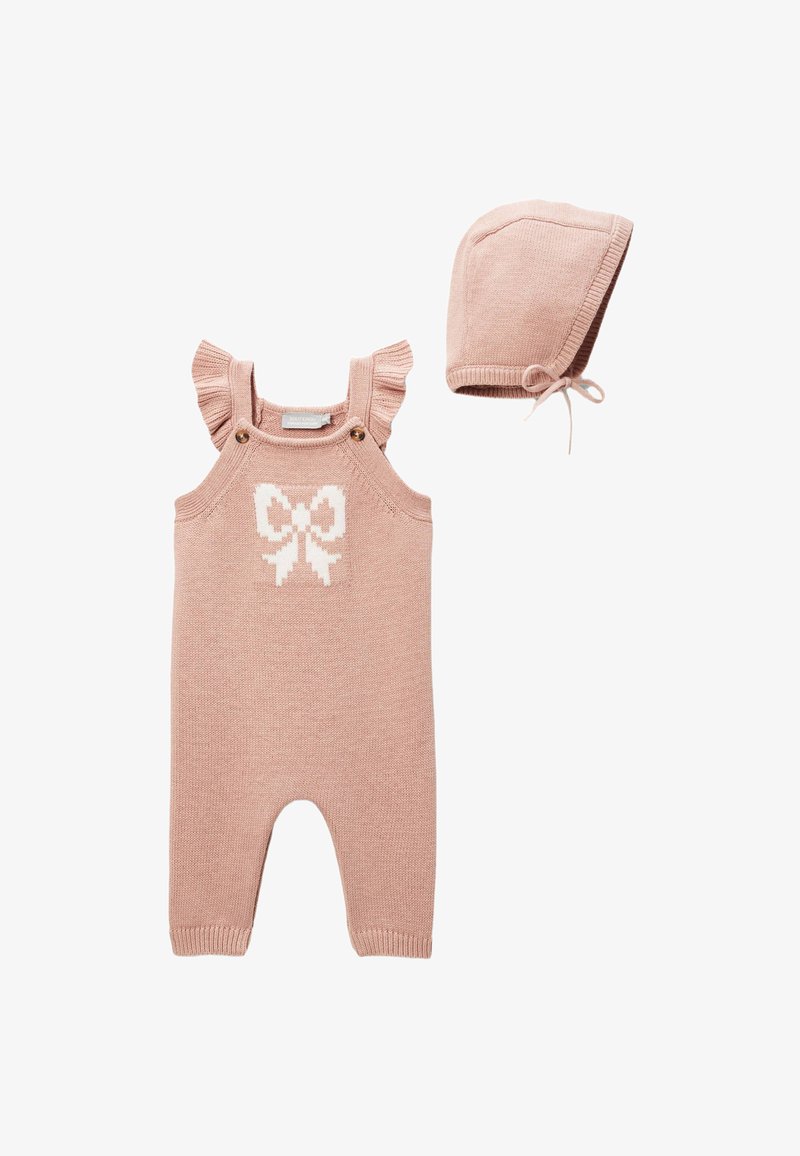Salopette rose tricotée avec bretelles à volants, motif nœud blanc sur la poitrine et bonnet rose assorti avec liens, en tissu doux.