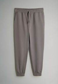 Grå sweatpants med elastisk talje og justerbar snor. Har sidelommer og tapered manchetter ved anklerne. Glat tekstur.