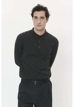 Dunkelgraues langärmliges Poloshirt mit kragenförmigem Ausschnitt und einer Dreiknopf-Leiste. Getragen mit schwarzen Hosen und einem Gürtel. Einfacher, strukturiertes Gewebe.