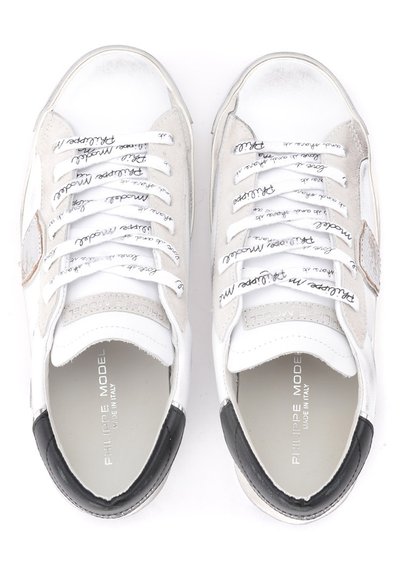 Sneaker bianche con accenti in camoscio, lacci piatti con nome del marchio stampato, punta arrotondata, dettaglio sul tallone nero e superficie testurizzata.
