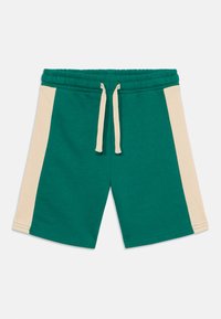 Shorts en coton verts avec des panneaux latéraux beiges, dotés d'une taille élastique et d'un cordon de serrage. Texture lisse, design à longueur de genou.