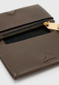 Portafoglio in pelle marrone con una finitura testurizzata, caratterizzato da una cerniera dorata e un interno nero. Dettagli accentuati a forma di triangolo sul davanti.