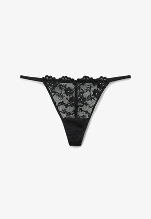 Tanga de encaje negro con detalles de patrón floral, tirantes finos ajustables y una cinturilla de encaje sólido que contrasta en diseño y textura.
