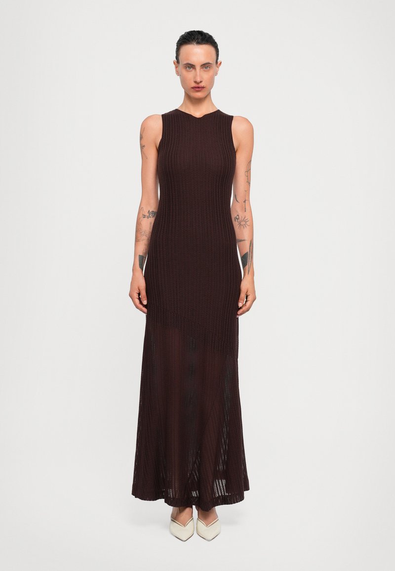 Brown ribbed knit maxi dress with a sleeveless design and a high neckline, featuring a sheer lower half and a straight silhouette.