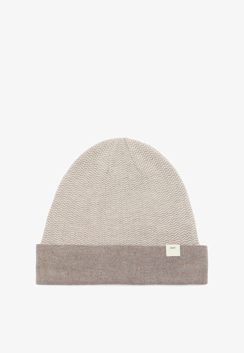 Berretto in maglia beige e marrone chiaro con risvolto e un delicato motivo a zigzag, caratterizzato da una piccola etichetta bianca del marchio sul risvolto.