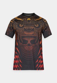 Μαύρο πουκάμισο με κοντά μανίκια και ζωντανό πορτοκαλί και κόκκινο γραφικό σχέδιο που παρουσιάζει περίπλοκα μοτίβα και ένα σχέδιο κρανίου σε όλο το ύφασμα.