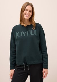 Mörkgrön sweatshirt med texten "JOYFUL", har en avslappnad passform, rund halsringning och justerbar dragrem vid fållen. Mjuk, bomullsblandning.