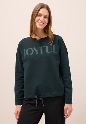 Tmavě zelená mikina s nápisem "JOYFUL", nabízící volný střih, kulatý výstřih a nastavitelné stahování v dolním lemu. Měkký materiál z bavlněné směsi.