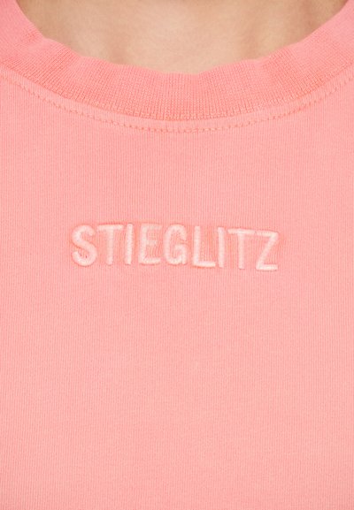 Pink cotton t-shirt with a ribbed texture. Features the embroidered word "STIEGLITZ" in matching pink thread on the front.